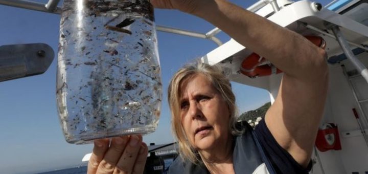 bote cristal con agua y multitud plásticos flotando en ella